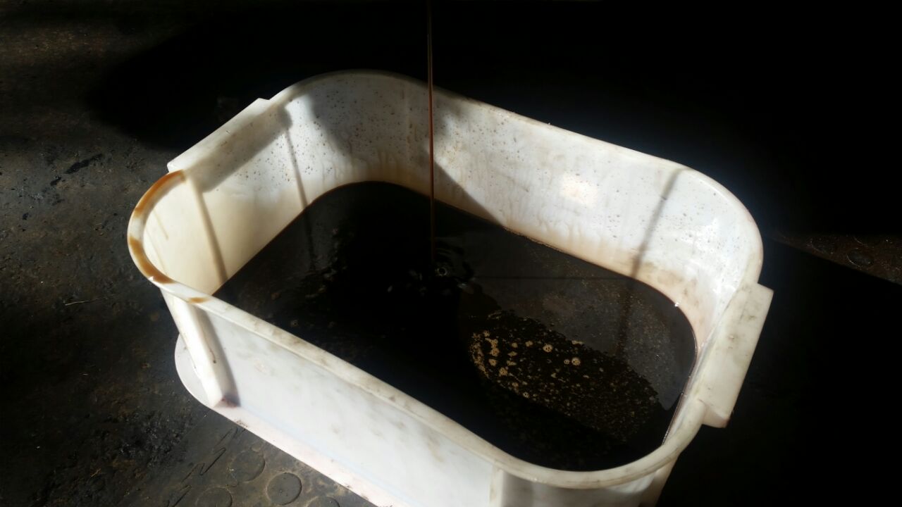 The oil drained into white container