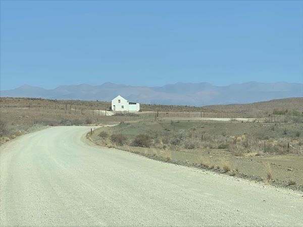 Lonely farm house on the gravel road to Prince Albert with the Swartberge in the background