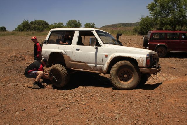 Strongman Ben lifting whilst Christo Boegman changes the tyre.